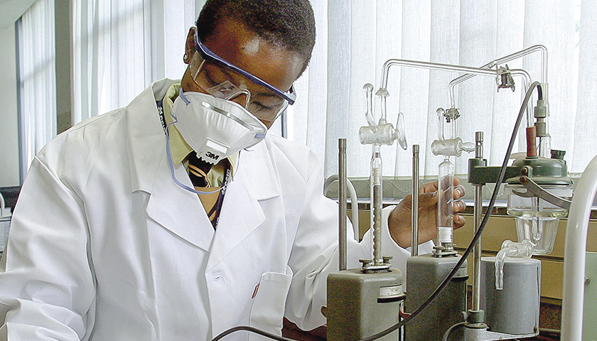 Black scientist with safety goggles and mask on