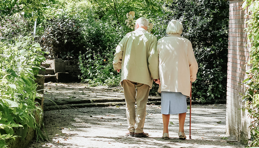 old man and woman walking outside together