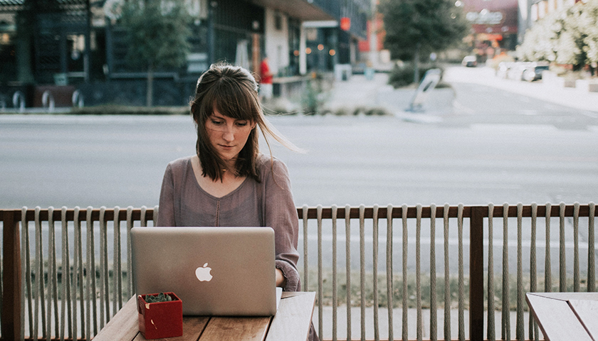 Woman on laptop working outside