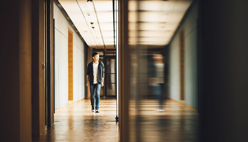 Boy walking down a school hallway